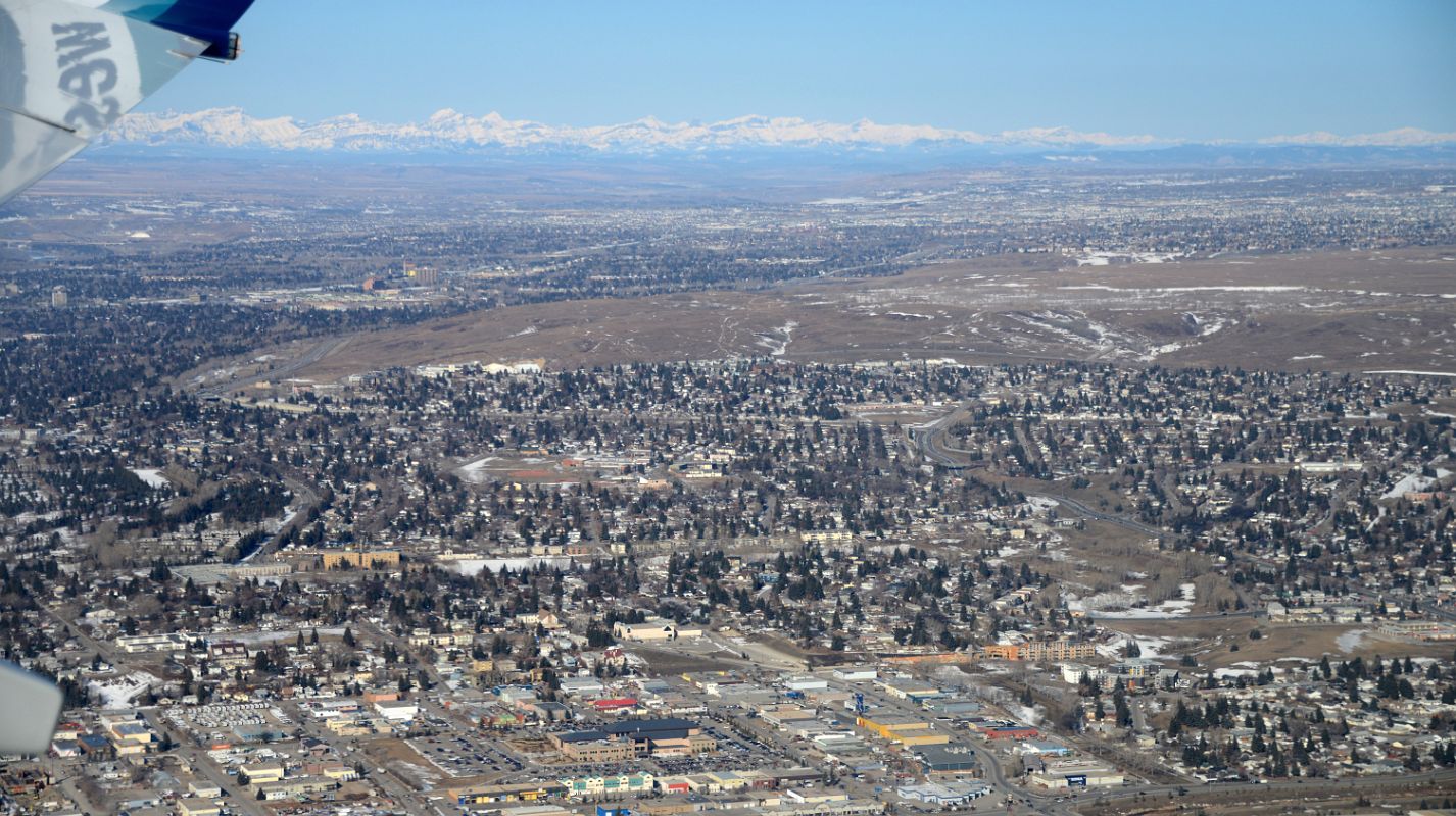 02D Calgary Is Spread Out With The Rocky Mountains In The Distance From The Air In Winter